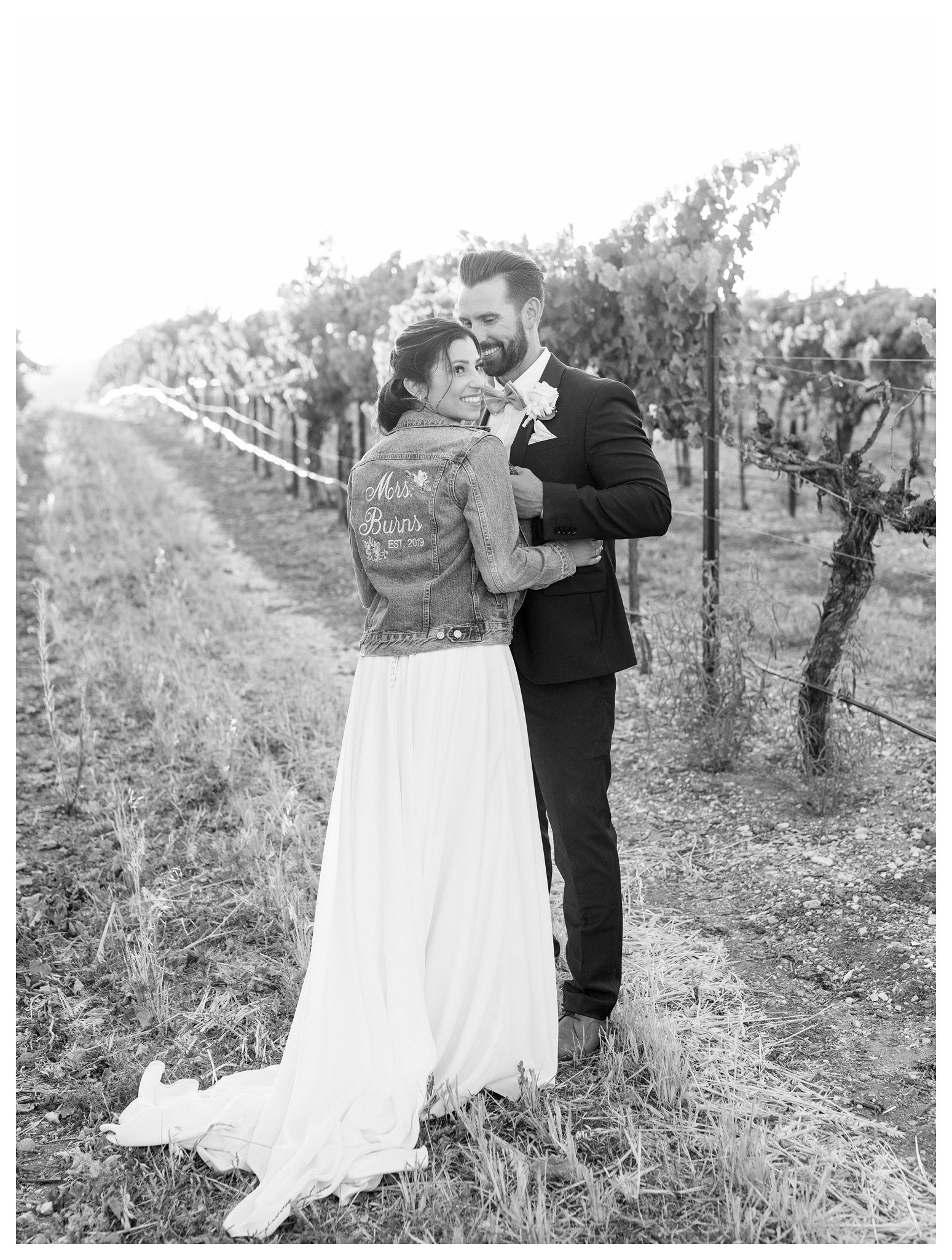 A bride and groom walk through the vines during golden hour. Photos at TERRA MIA Vineyards in Paso Robles, California for a romantic moment together.