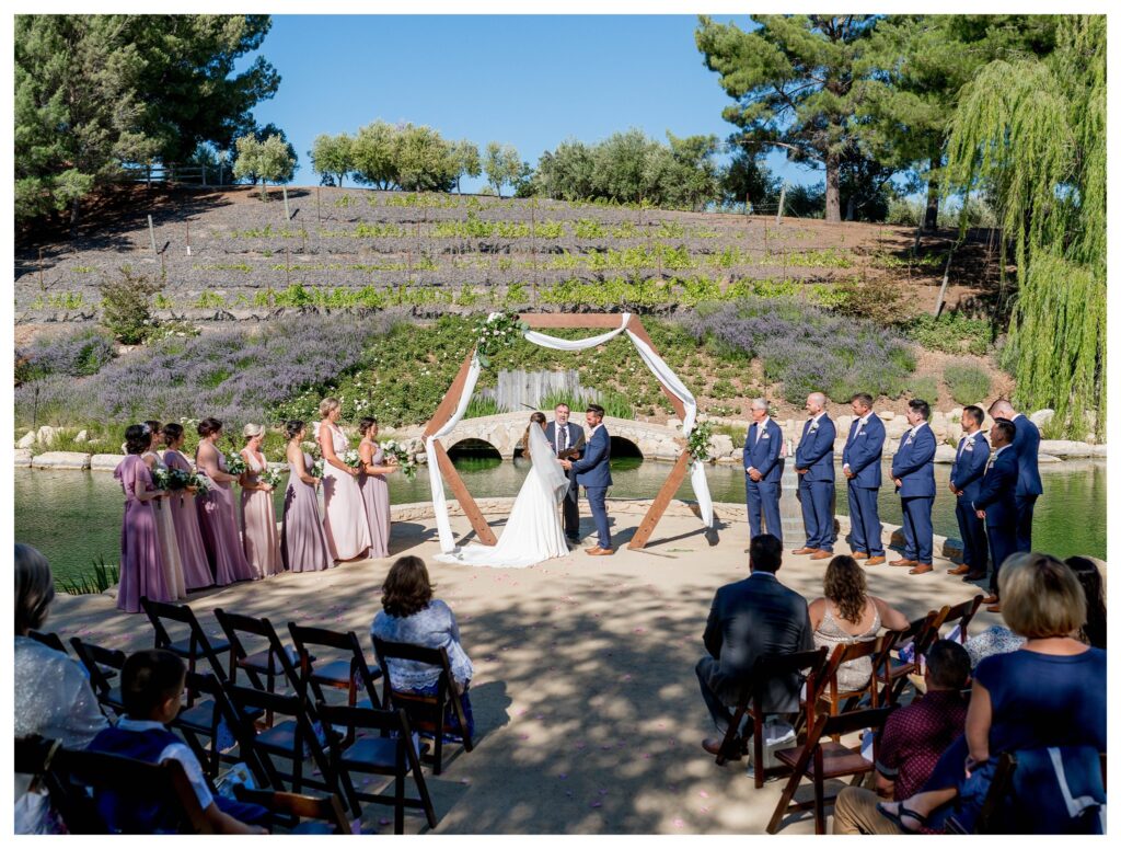 A wedding ceremony at TERRA MIA vineyards in Paso Robles California overlooking the pond and Willow trees