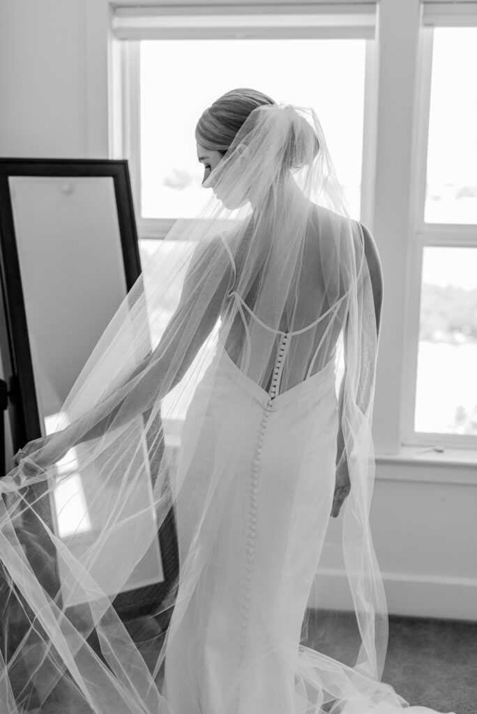 A candid moment where the bride looks into the mirror before her wedding ceremony begins at Ellas Vineyard.