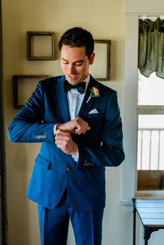 A groom gets ready for the ceremony by fixing his cufflinks at Ellas Vineyard in Paso Robles.