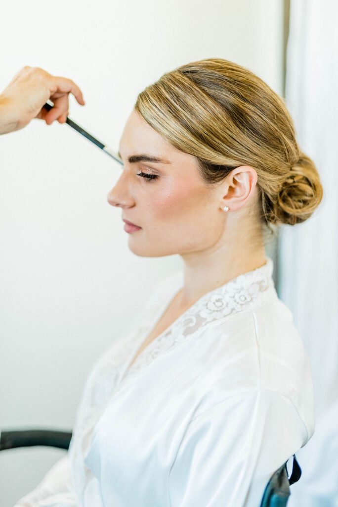A bride gets make up done before her wedding at Ellas Vineyard.