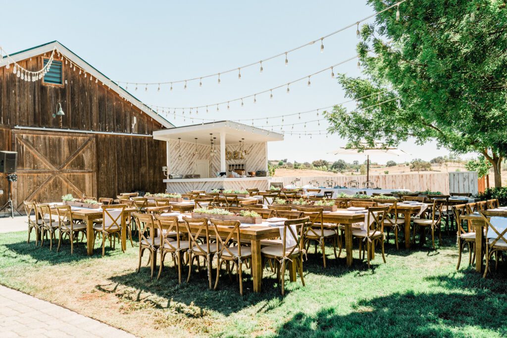Tables and chairs, set up for a wedding reception in front of the barn at Ellas Vineyard a vineyard wedding venue near Paso Robles.