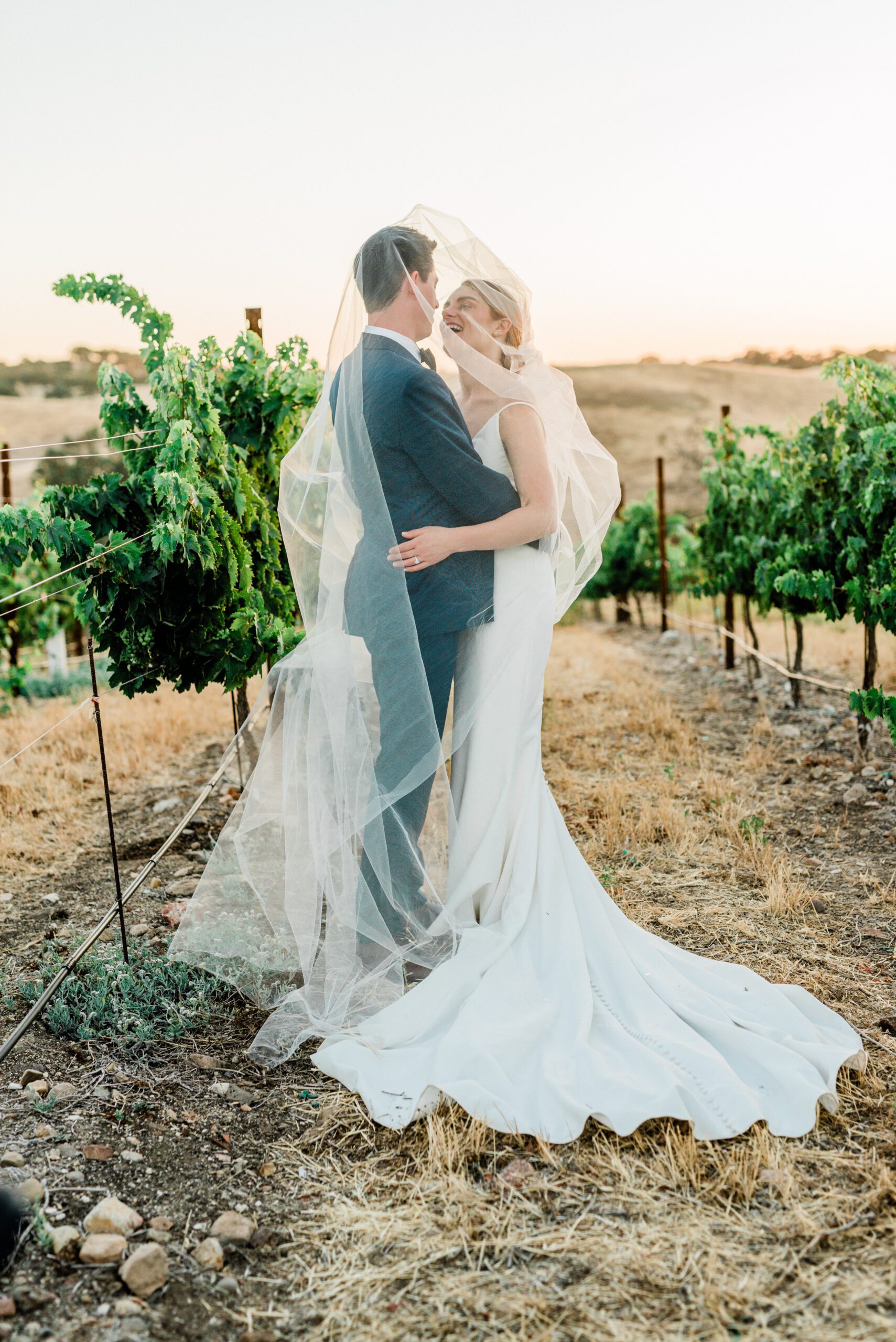 Bride and Groom laugh during a romantic moment on their wedding day at Ellas Vineyard in Creston California.