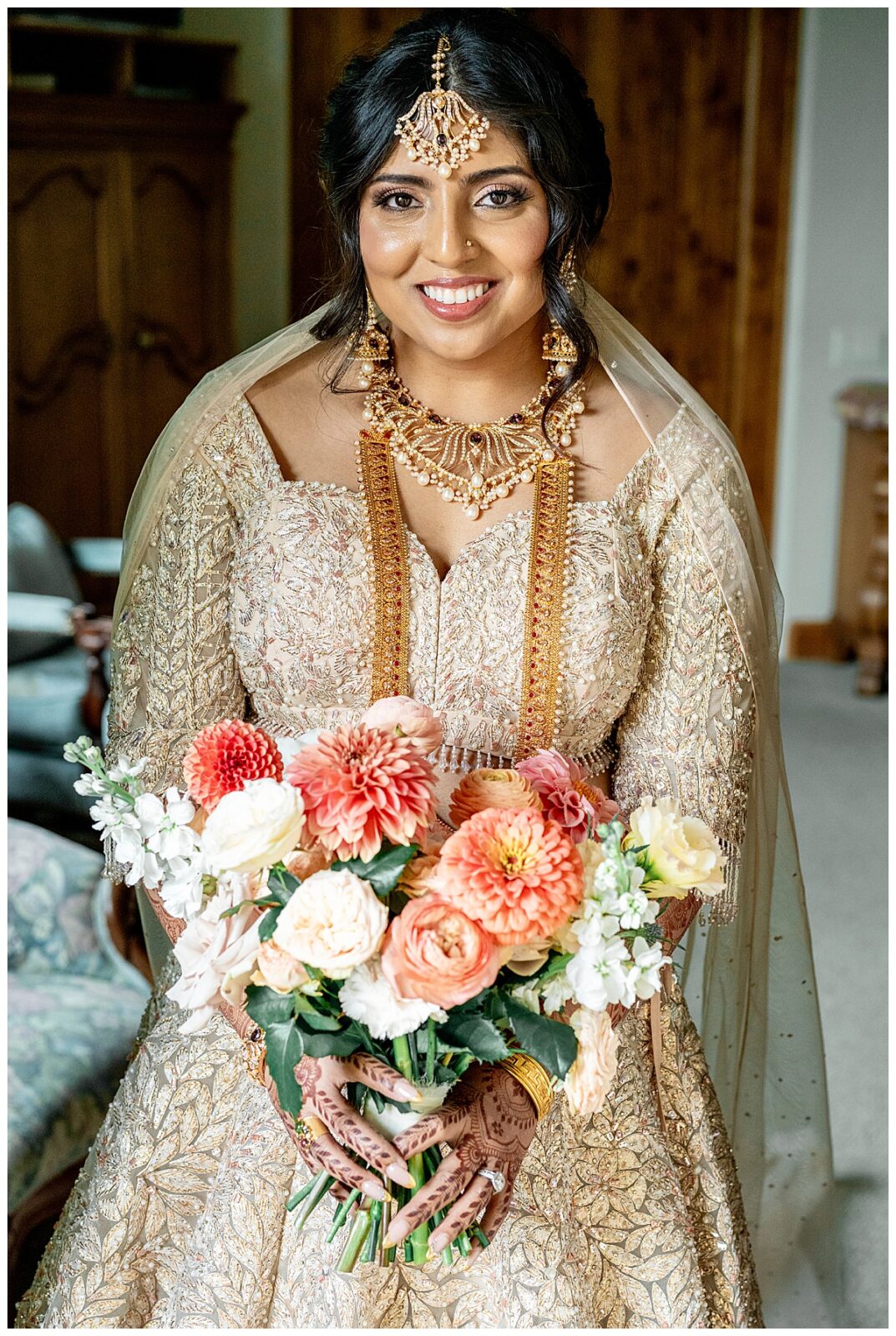 A bride in her traditional Indian wedding dress holding a colorful spring bouquet of flowers at Willow and Oak Estate in Paso Robles.