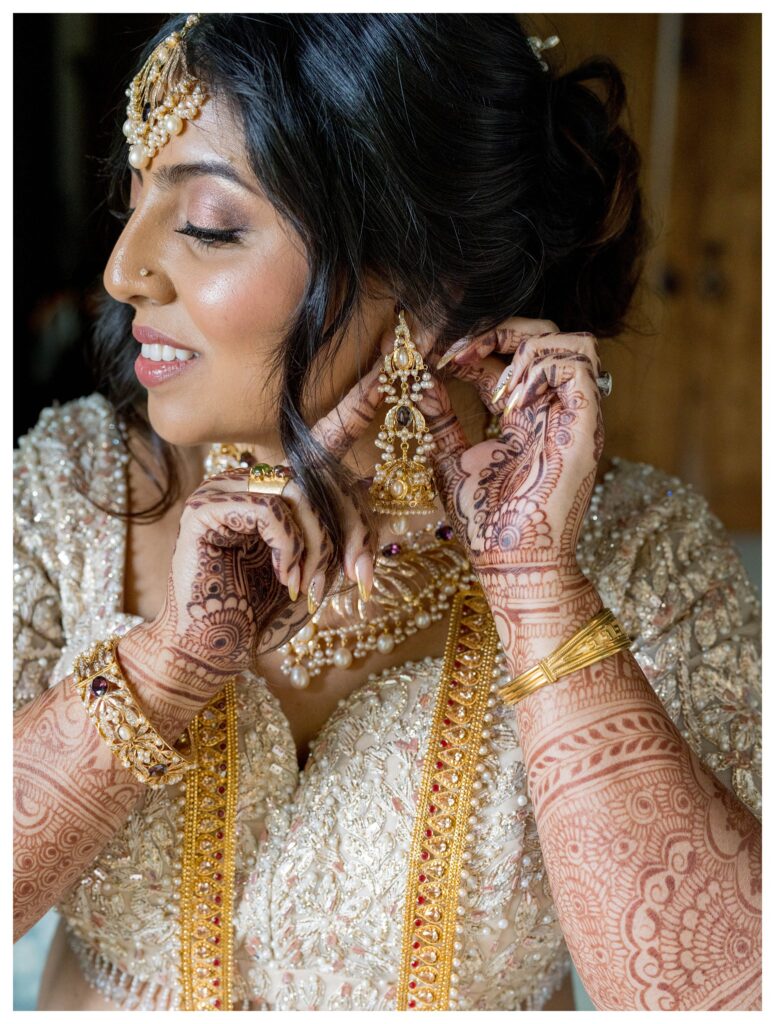 Bride adjusting earrings with mehndi – Indian wedding in Paso Robles – Leana Myra Photography