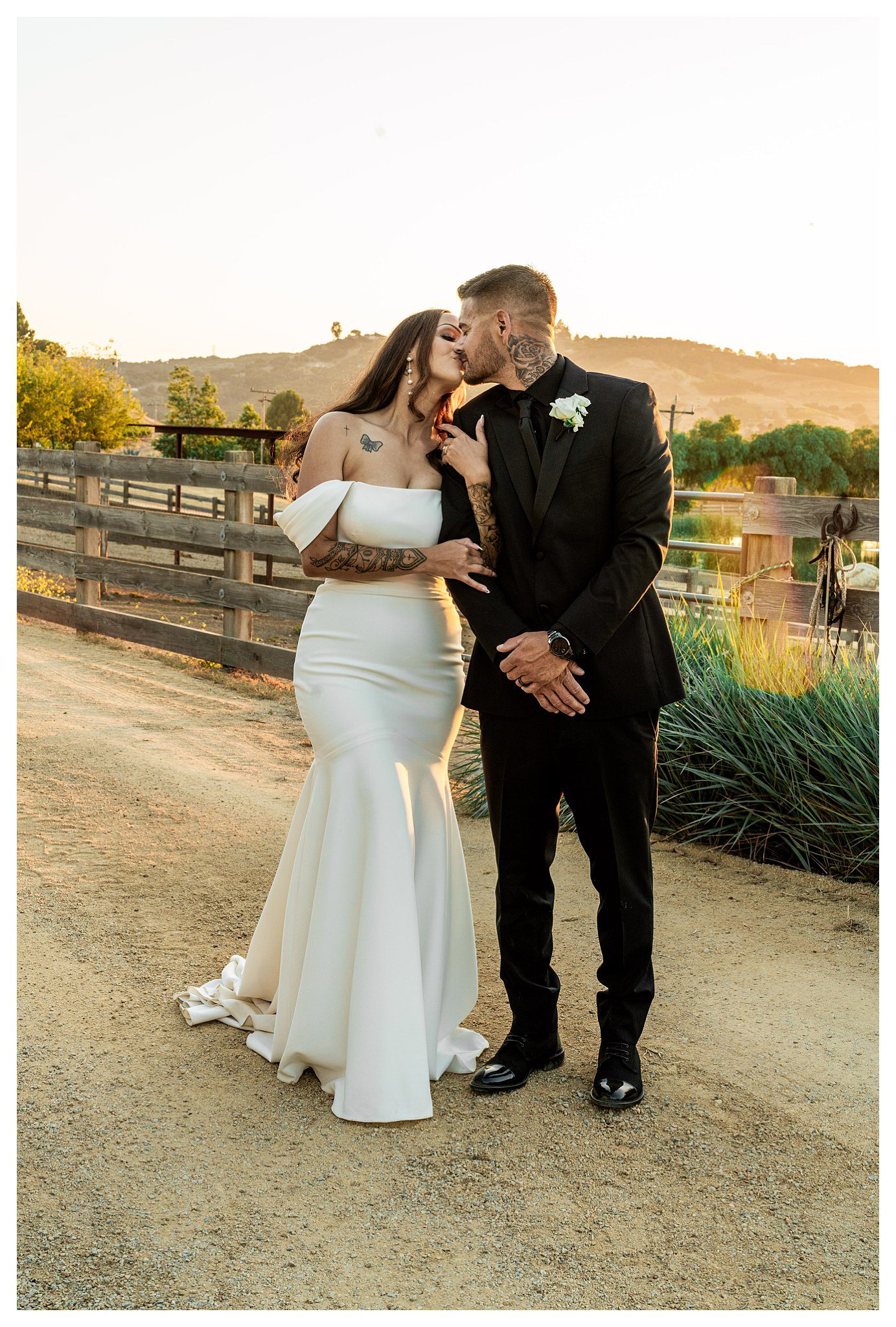 Bride and groom kiss at sunset during chic and elegant barn wedding at Marfarm, and San Luis Obispo Barn wedding venue.