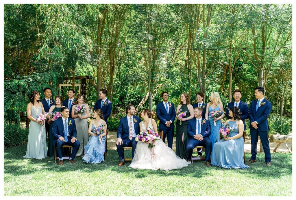 A wedding party in spring colors posed for a photo at Hartley farms, a san luis obispo garden wedding venue. 