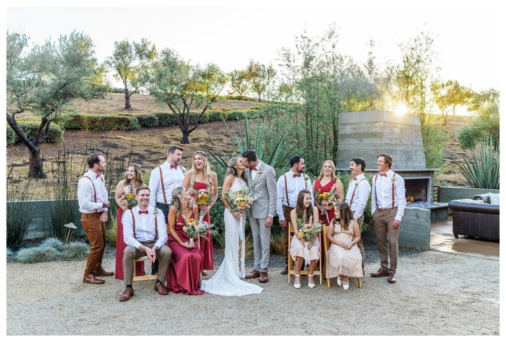 A wedding party in fall colors pose together at Flying Caballos Ranch, a san luis Obispo vineyard wedding venue.