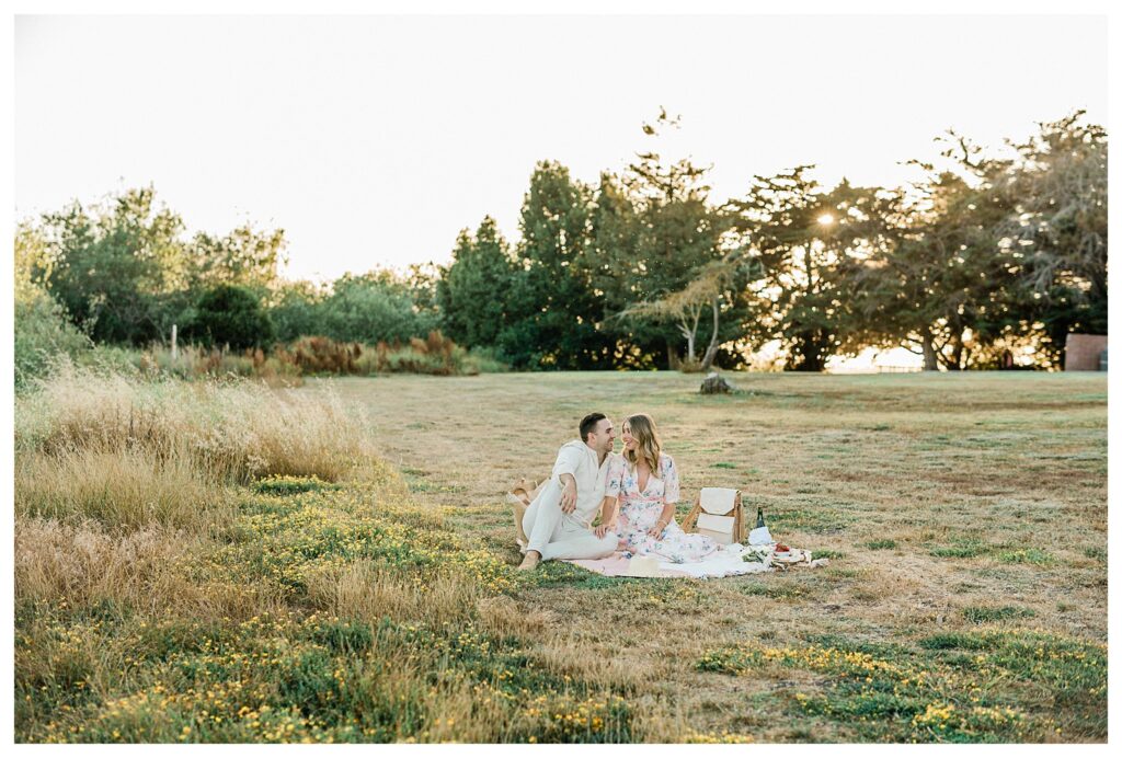 romantic couple having a sunset picnic for their engagement session 