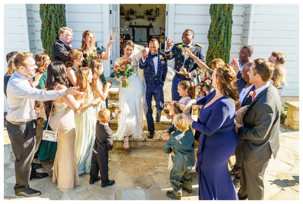 Wedding guest, throw flowers as a bride and groom, exit their church wedding ceremony during their San Luis Obispo California wedding day.