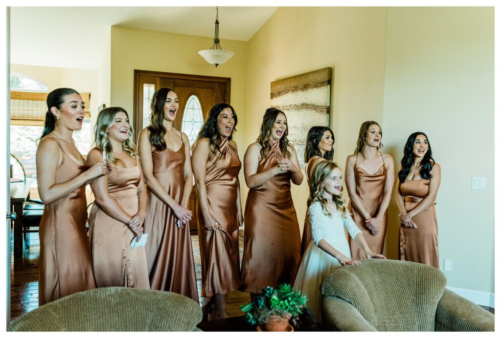 A bride  does a reveal for her bridesmaids before her Slo Brew Rock wedding in San Luis Obispo. 