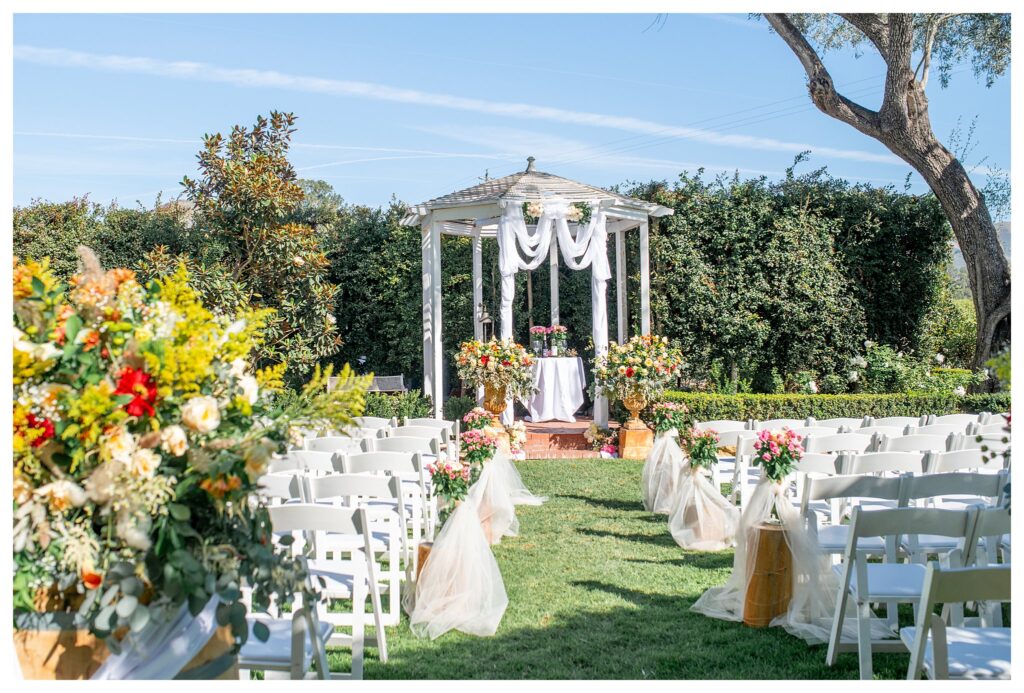 A wedding ceremony in the Dana Powers House gardens, full of fall flowers and colorful decor. Dana Powers is a wedding venue in San Luis Obispo with a garden.  