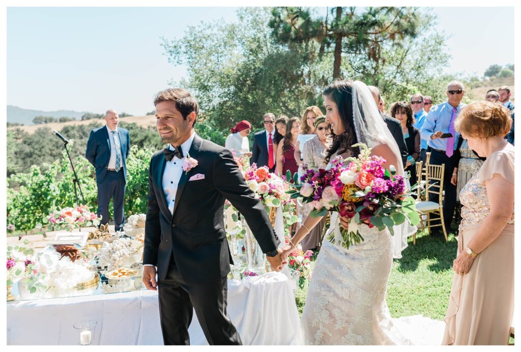 Aa bride and grrom walk around their sofreh at a persian wedding ceremony in San Luis Obispo at the Casitas estate.