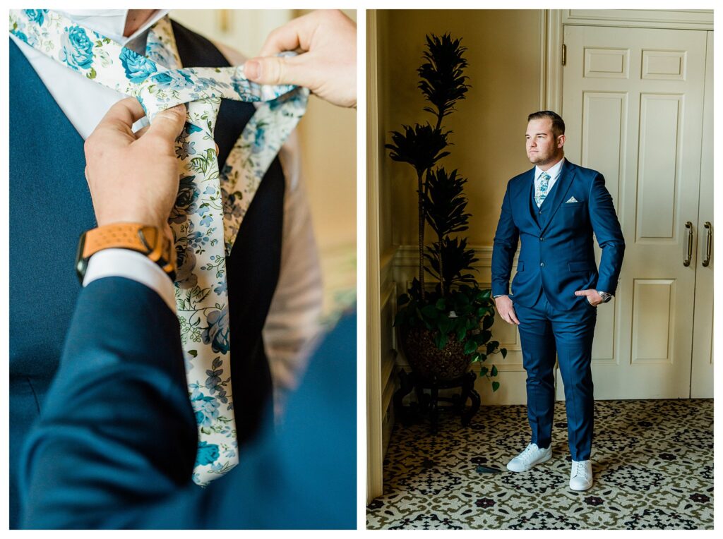 Groom getting ready in dark navy suit and floral tie at Sherwood Country Club.