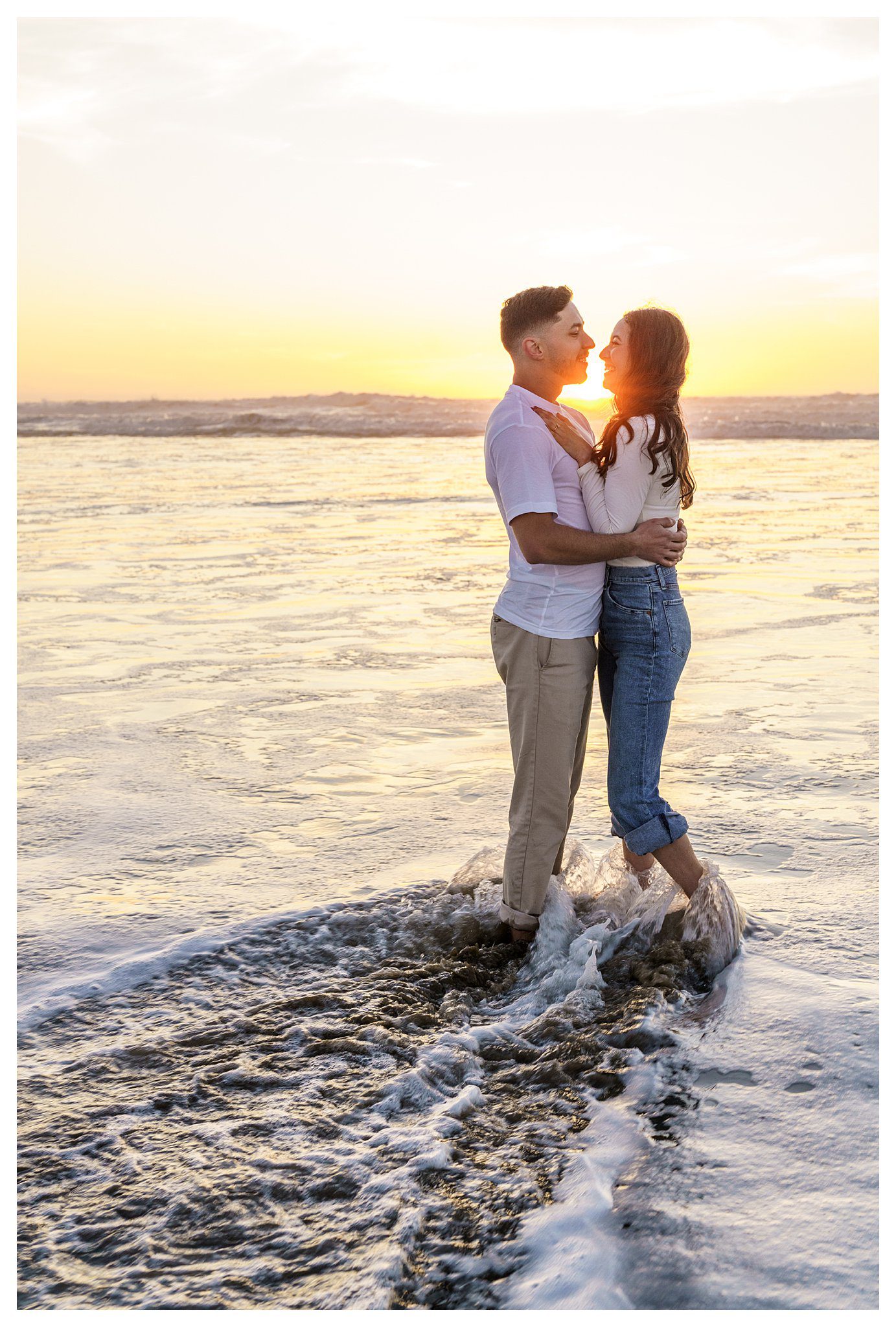 And engagement photographer near you takes a photo of a woman and a man kissing at sunset in the waves and San Luis Obispo.