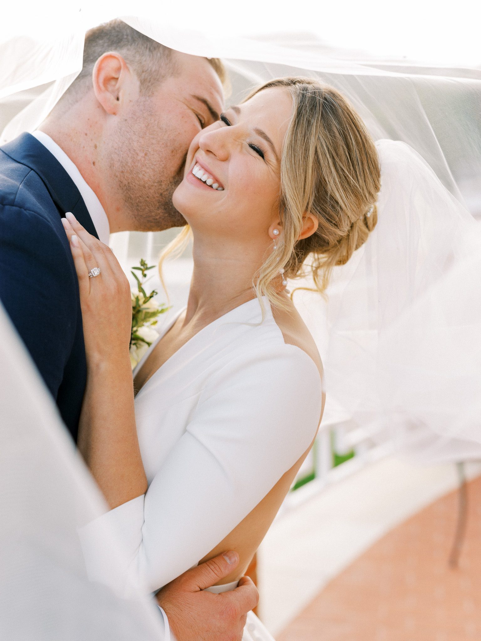 "Bride and groom sharing a kiss under olive trees in Central California"
