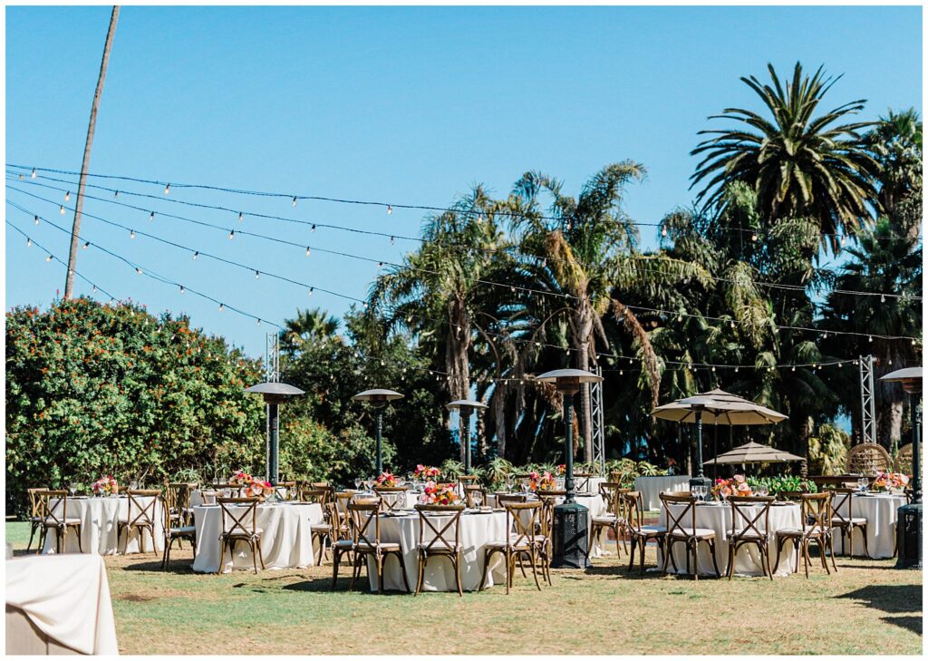 Tables and chairs set up for a wedding reception at the Santa Barbara zoo during a colorful and tropical wedding day.
