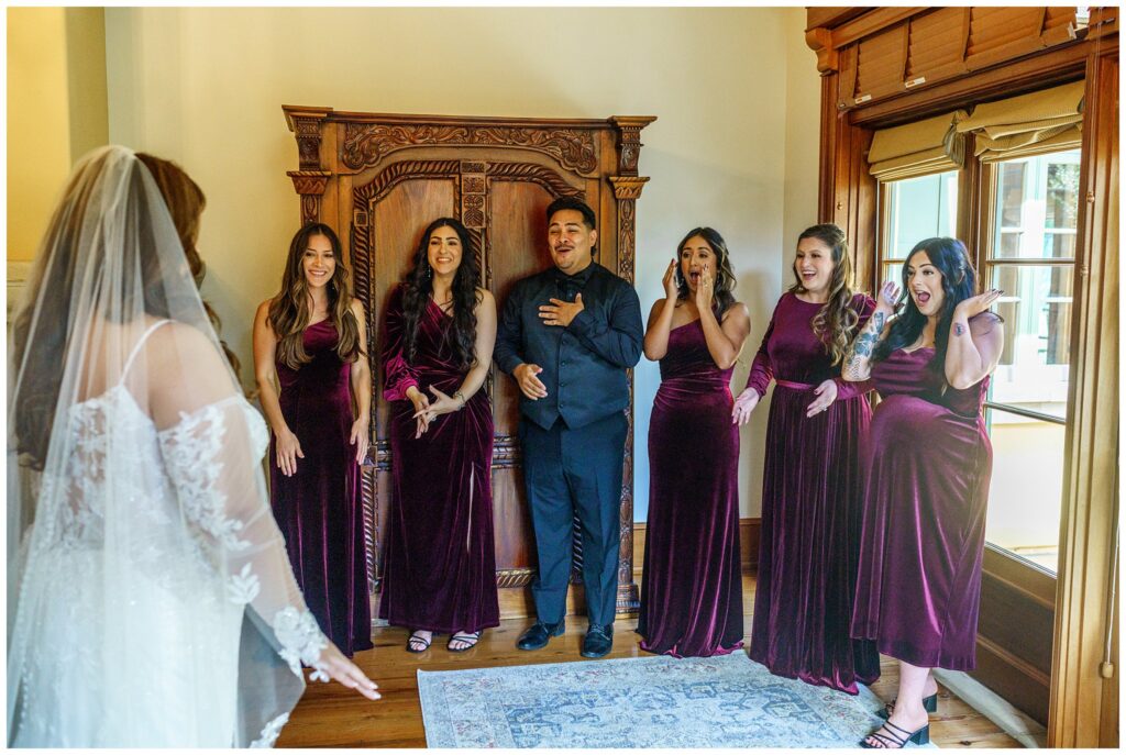 A bride sees her wedding party for the first time, and they react with happiness, love and appreciation of her beautiful wedding dress during her wedding at Cali Paso, winery, and Villa in Paso Robles.