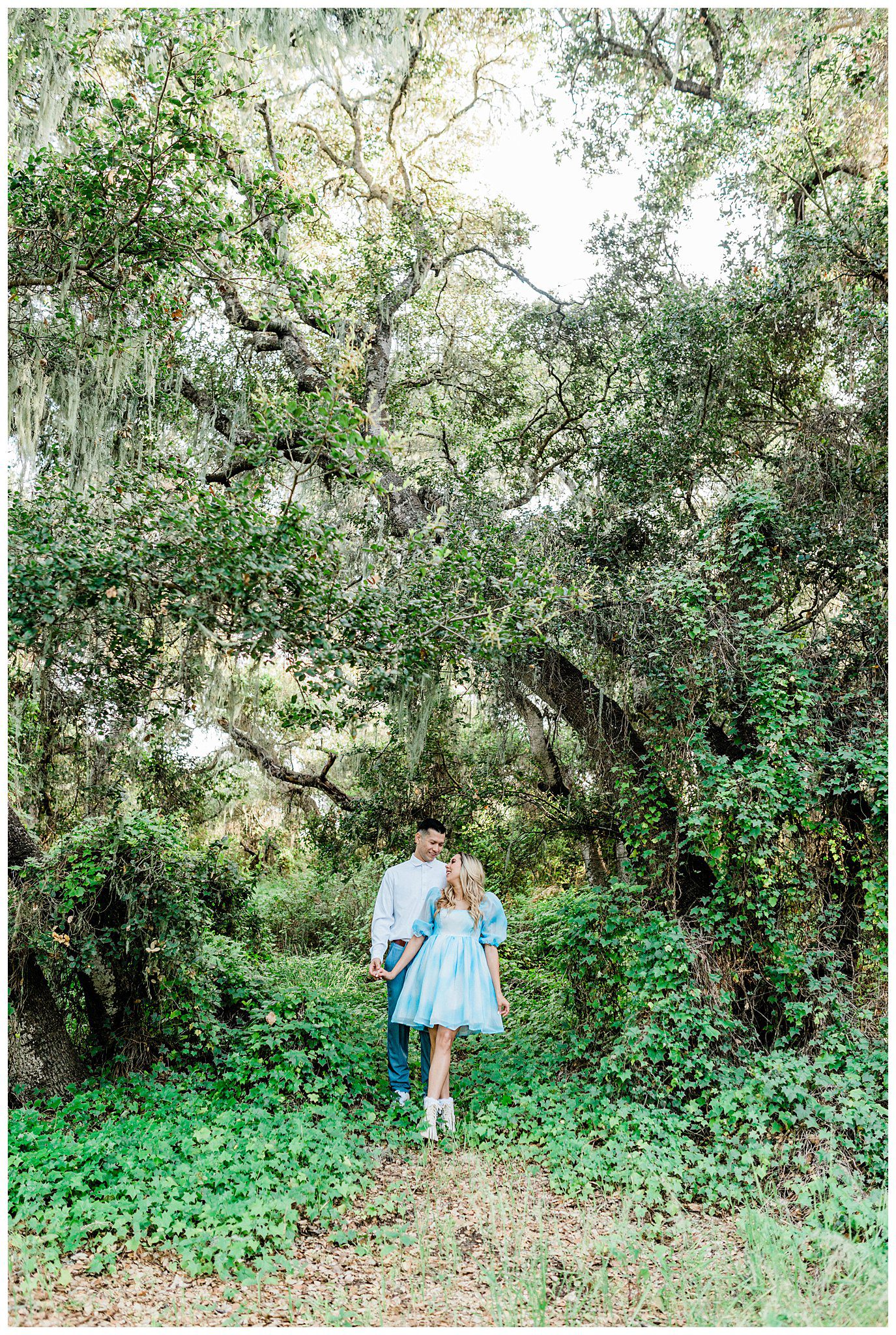 Engaged couple holding hands during a whimsical and fairytale inspired forest engagement session in the Los osos oaks reserve.