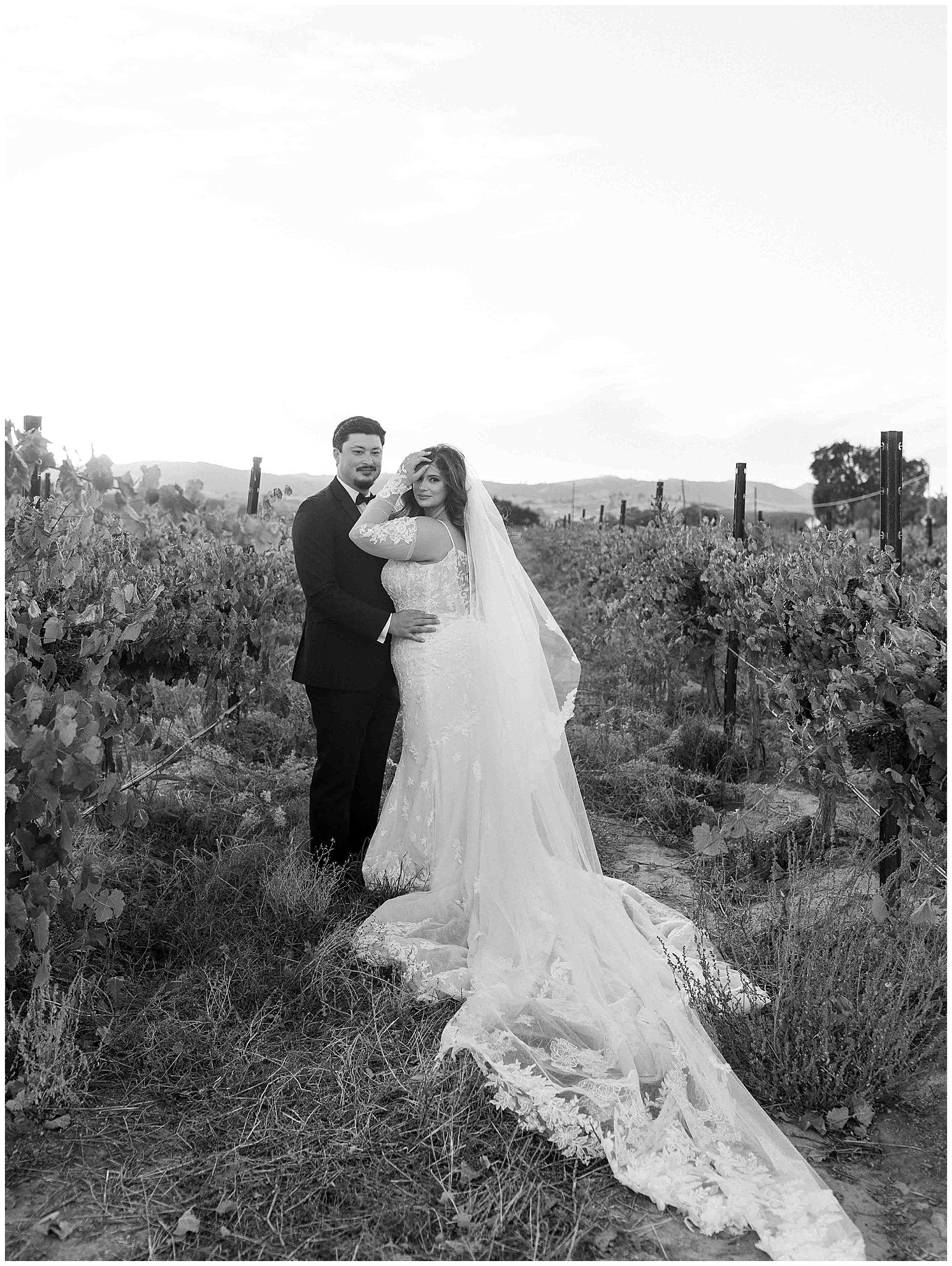 Bride and groom sharing an intimate veil moment in Paso Robles vineyard, captured with romantic elegance by Leana Myra Photography.
