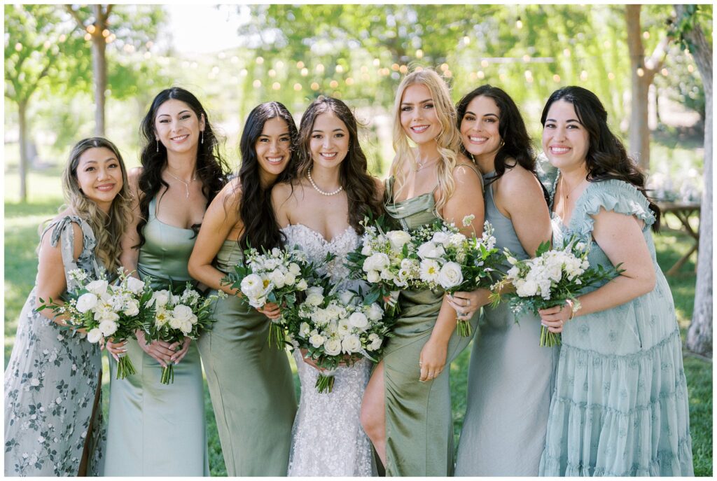 Bridesmaids in green and white, holding classic wedding flowers at Bella Terra Vineyards in Paso Robles, California during a spring wedding.