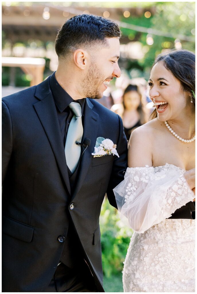 A bride and groom laugh happily during their wedding ceremony at Bella Terra Vineyards, in Paso Robles, California.