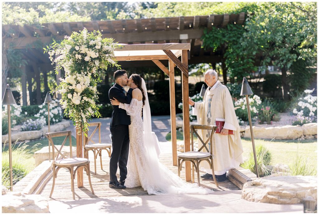 A bride and groom kiss during their wedding ceremony at Bella Terra Vineyards in Paso Robles, California.