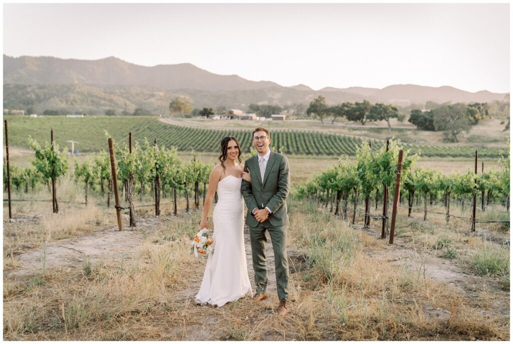 Couple stands in the vineyards at Oyster ridge winery in paso robles during their wedding day.