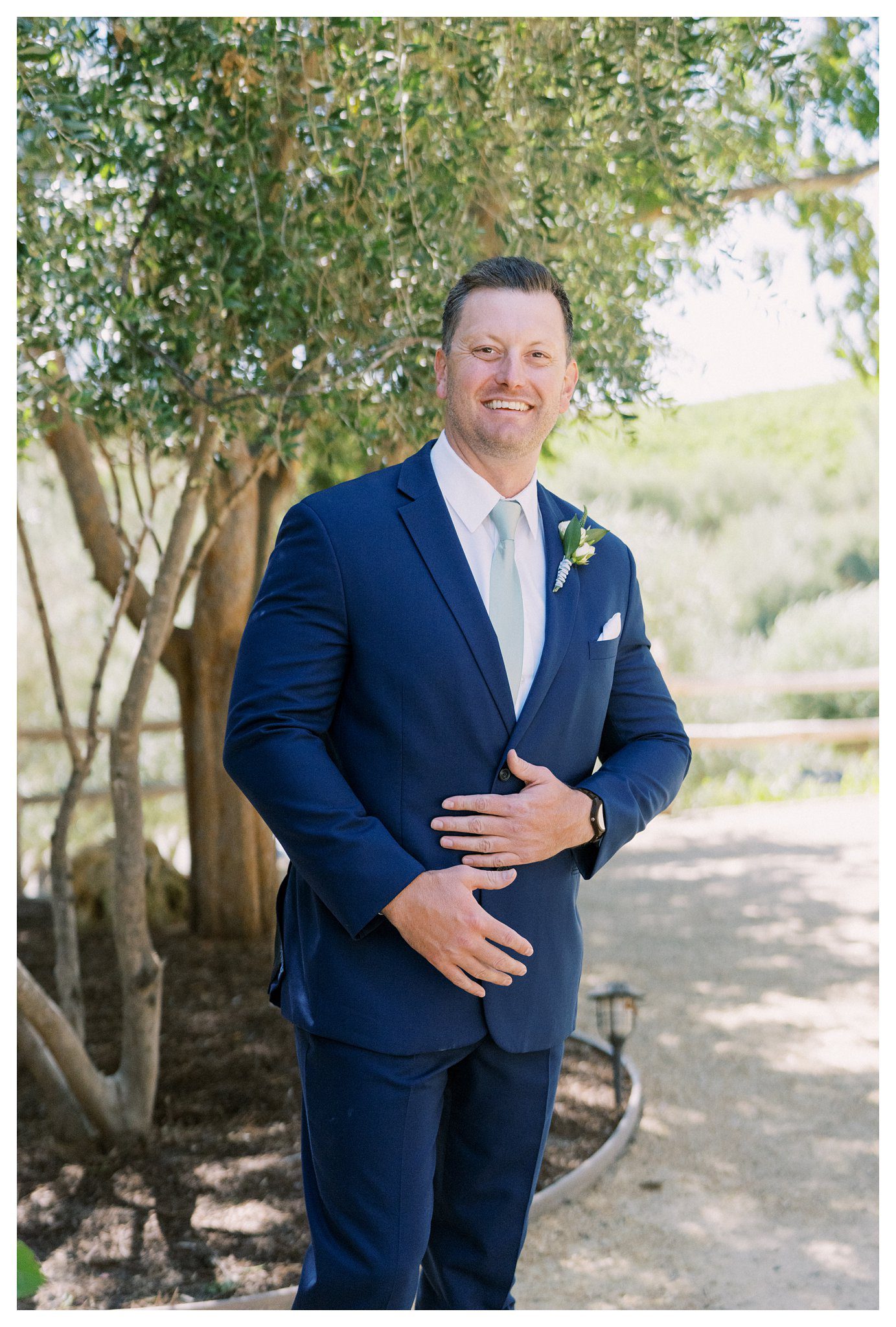 Groom in blue suit smiling at Terra Mia Vineyard wedding