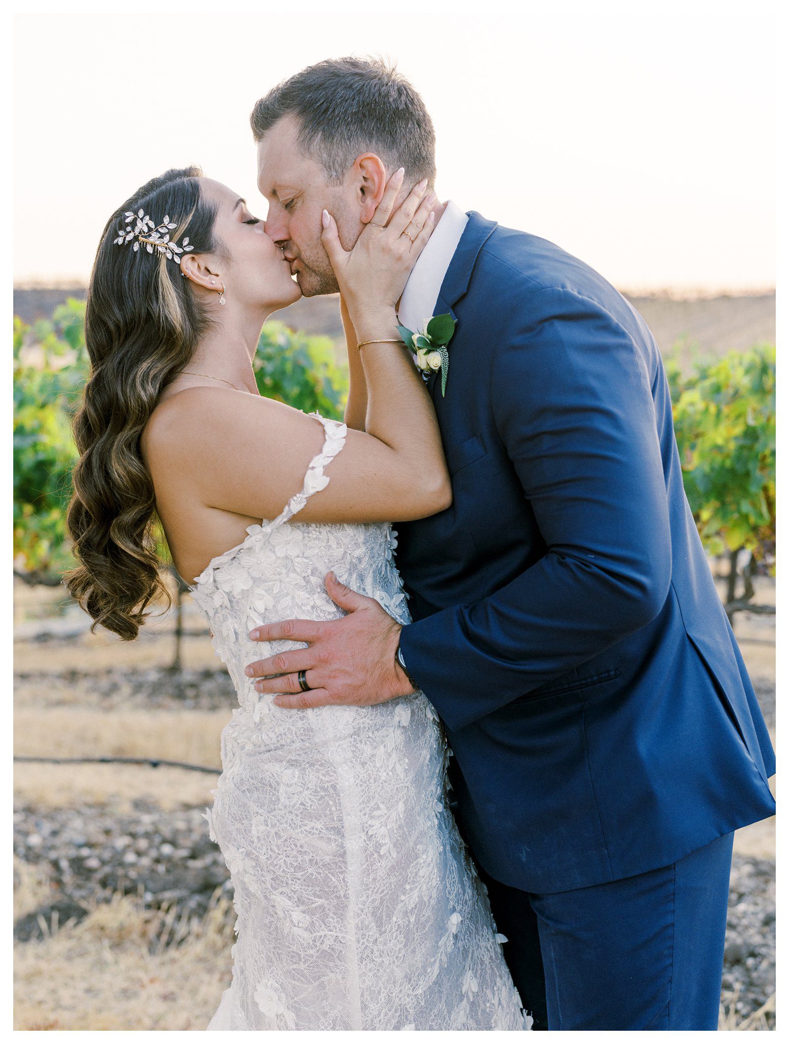 Romantic vineyard kiss at sunset with floral hairpiece