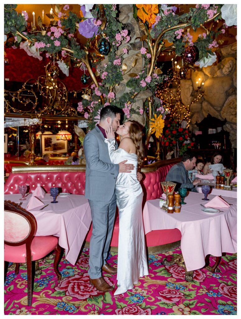 Kiss under florals – Romantic Kiss | Madonna Inn Wedding | Leana Myra Photography