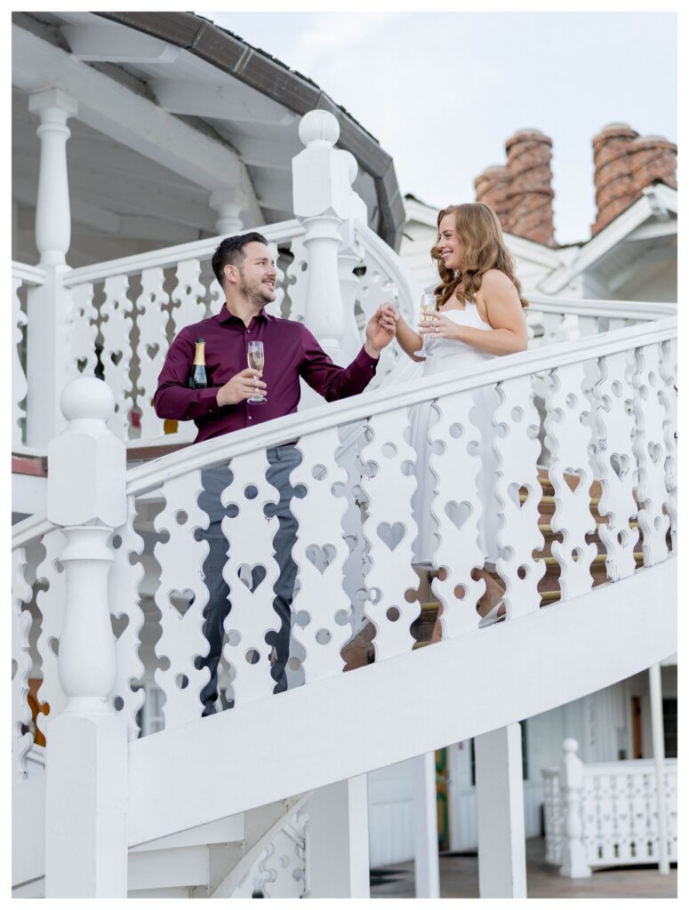 Couple in staircase with white wine – Romantic Walk | Madonna Inn Wedding | Leana Myra Photography
