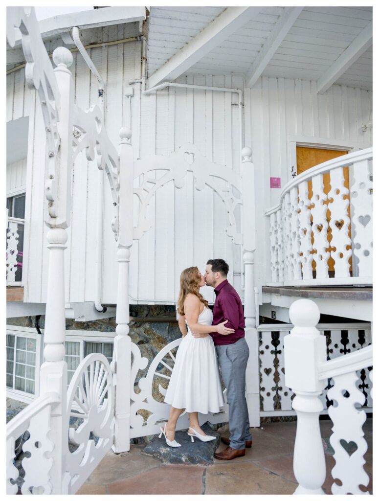 Couple kissing under white arch – Whimsical Romance | Madonna Inn Wedding | Leana Myra Photography